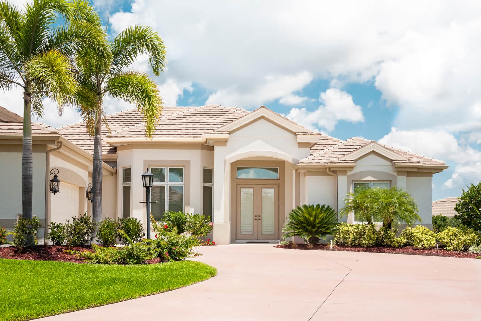 Beautiful new Florida home in the tropics; palm trees, tropical foliage, wide driveway