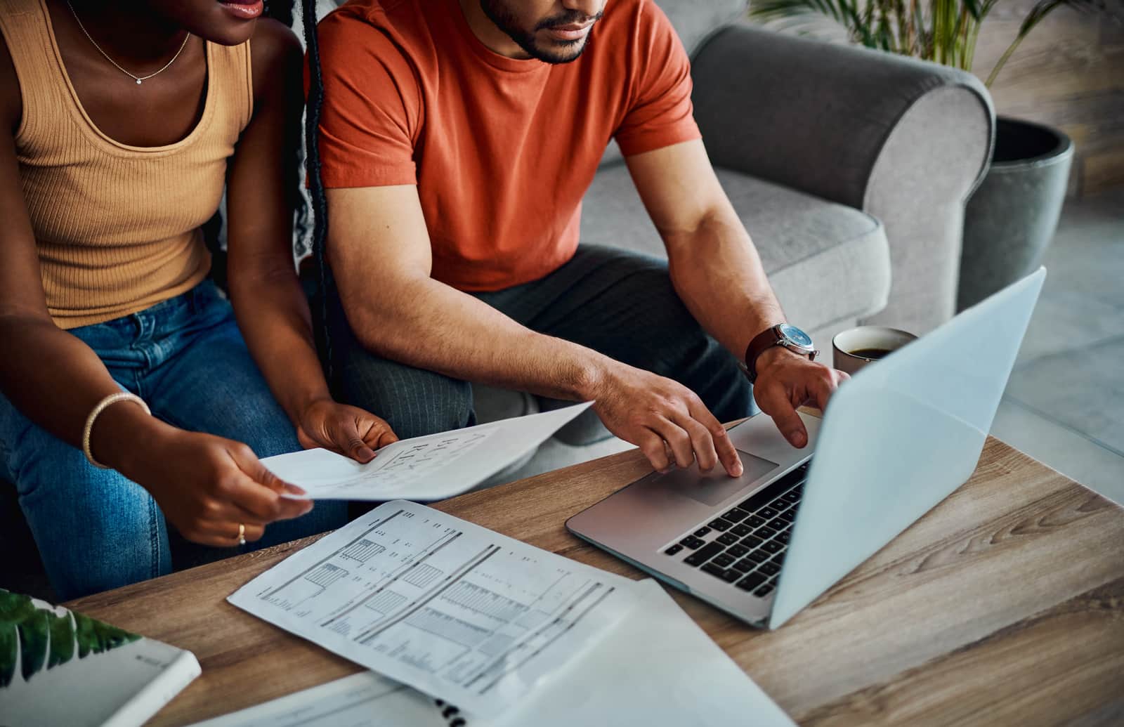 couple sitting in the living room and using a laptop to calculate their finances