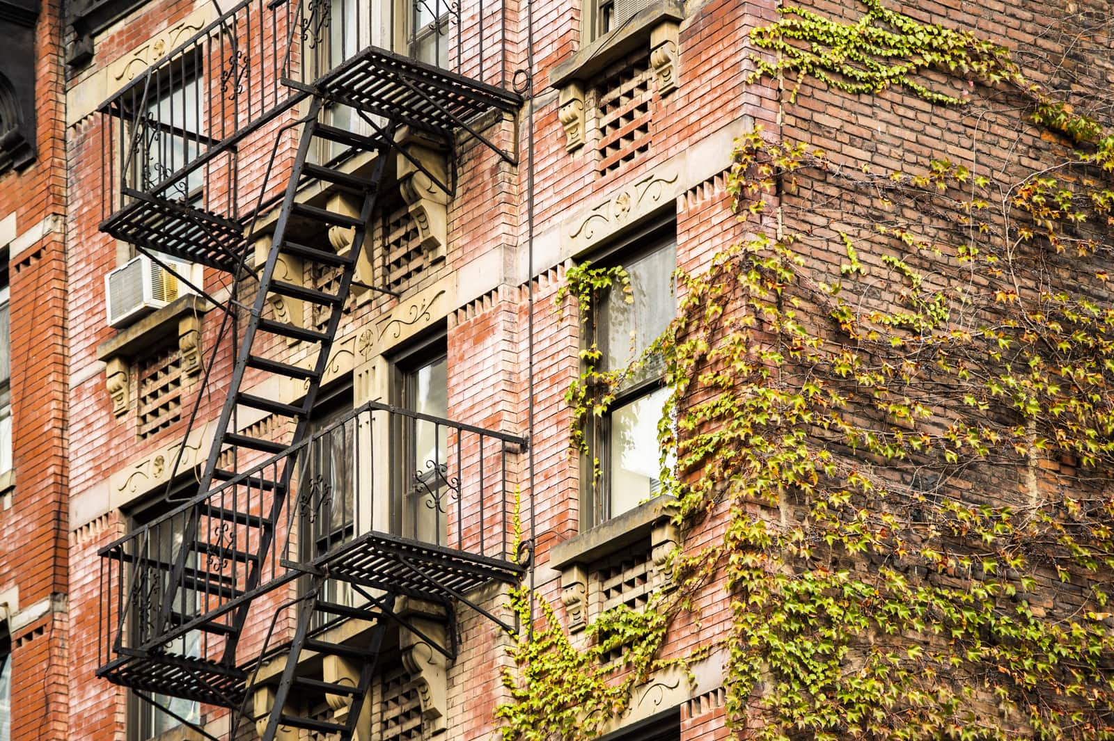 Close-up view of New York style apartment buildings with fire escape stairs